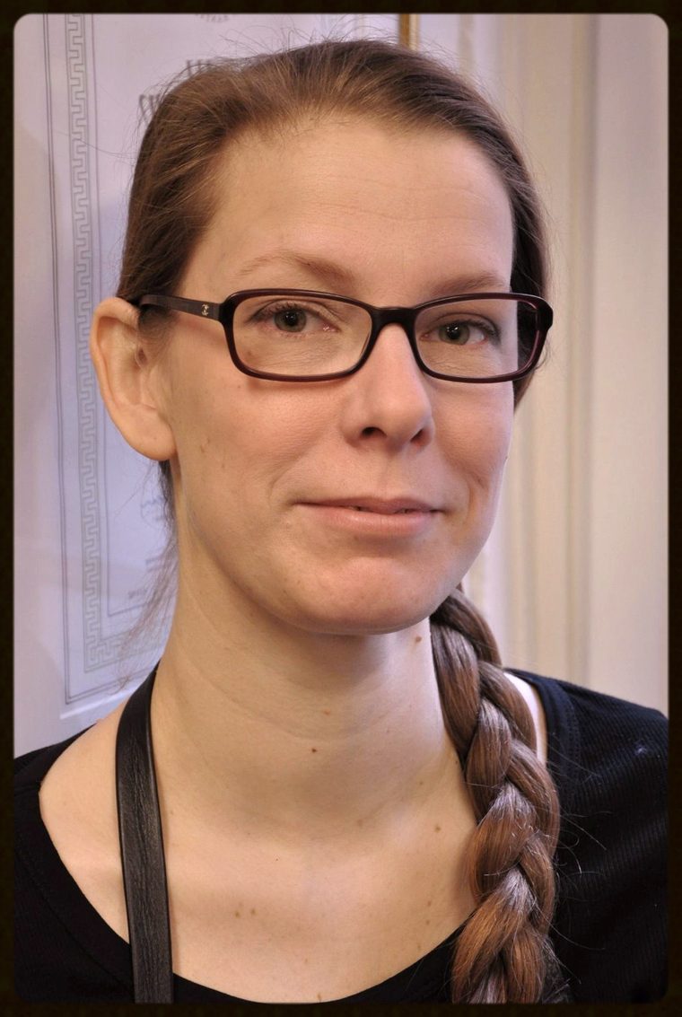 Anna Lindqvist i l&auml;derf&ouml;rkl&auml;de framf&ouml;r sitt inramade ges&auml;llbrev